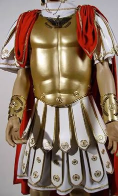 a gold and white roman soldier costume with red cape on his head, standing in front of a white background