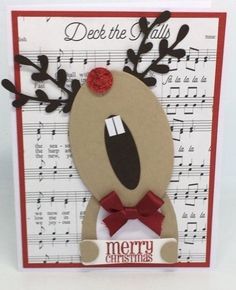 a christmas card with reindeer's head on top of sheet music and red ribbon