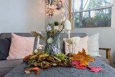 a living room filled with furniture and fall leaves