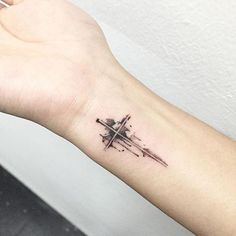 a cross tattoo on the wrist