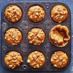 muffins in a baking pan on a blue surface with other muffins