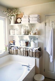 a bath room with a tub and shelves filled with towels