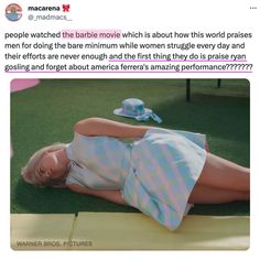 a woman laying on the ground with her arms around her body and wearing a blue striped dress