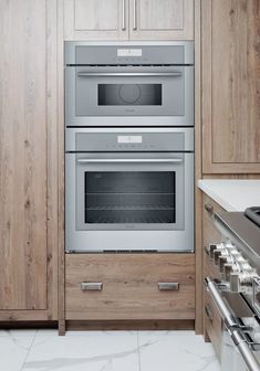 two ovens in a kitchen with wooden cabinets