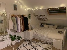 a bed room with two beds and lots of clothes hanging on the wall next to each other