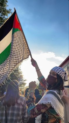 a woman holding up a flag in front of other people