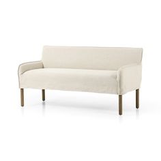 a white couch sitting on top of a white floor next to a wooden leg chair