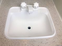 a bathroom sink with two faucets on the top and one in the middle