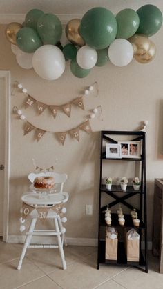 a baby's first birthday party with balloons, cake and bunting garlands