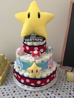 a three tiered cake with mario and friends on it's sides, topped with a giant star