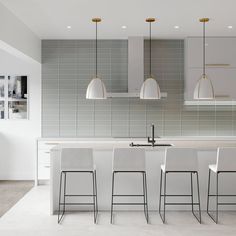 a kitchen with white counter tops and bar stools