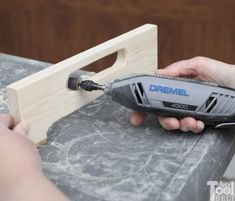 a person using a drill bit to attach a piece of wood