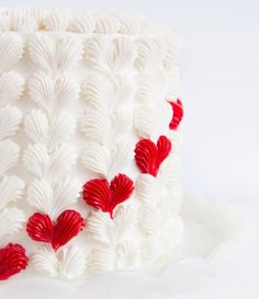 a white cake with red hearts on it