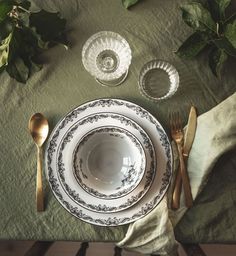 an empty plate and silverware on a green table cloth