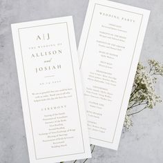 two white wedding programs with gold foil on them, sitting next to some baby's breath flowers