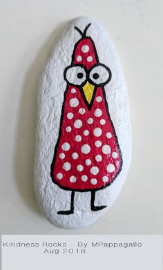 a painted rock with a red bird on it's face and polka dot dots