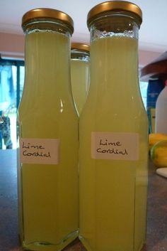 there are two bottles with lemonade in them on the kitchen counter top, one has a label that says lime cordial