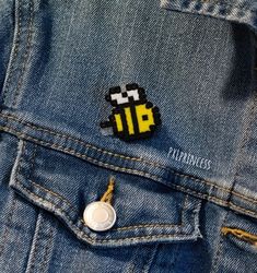 a pacman pin sitting on top of a denim jacket