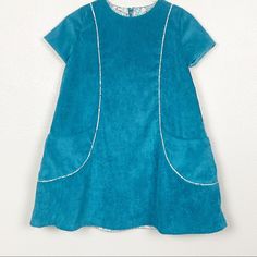 Girl's Teal 100% Organic Cotton Corduroy Fully Lined A Line Dress With Cap Sleeves, Round Collar, Piping Detail, Wrap Around Pockets And Concealed Back Zipper. Hand Wash In Warm Water, Lay Flat To Dry. Size 7. Measurements (Flat Lay - Approx) Length: 26" (Shoulder Seam To Bottom Of Dress) Chest: 15" (Pit To Pit) Green Toddler Dress, Toddler White Dress, Pink Gingham Dress, Dress With Cap Sleeves, Striped Dress Summer, Peter Pan Collar Dress, Red Floral Dress, Summer Stripes, Pink Gingham