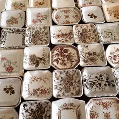 many plates are stacked on top of each other in different patterns and sizes, all decorated with flowers