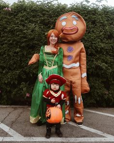 a woman and child standing in front of a giant ginger costume with a pumpkin on it