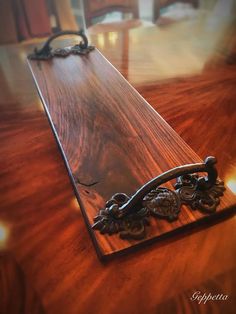 a close up of a wooden table with an ornate handle on it's end