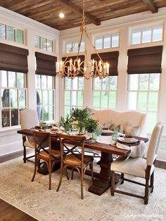 a dinning room table with chairs and a chandelier hanging from the ceiling