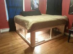 a bed that is sitting in the middle of a room with red walls and wooden floors