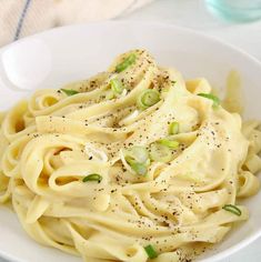 a white bowl filled with pasta and sauce