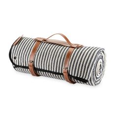 a black and white striped duffel bag with brown straps on the bottom, in front of a white background