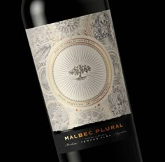 a bottle of malbec plural wine on a black background with an intricate design