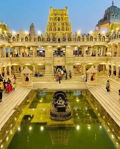 people are standing in the middle of a large building with a fountain and water feature