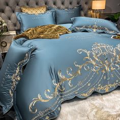 a bed with blue and gold comforters on it