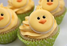 some cupcakes with yellow frosting are decorated like chickens and have faces on them