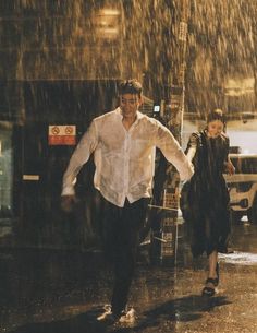 a man and woman walking in the rain