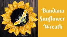 a yellow and black sunflower wreath with a bee on it's center piece