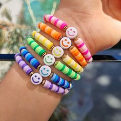 a person's arm with colorful bracelets and smiley face buttons on the wrist