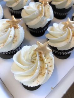 cupcakes with white frosting and gold star decorations