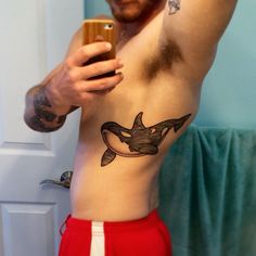 a man with a tattoo on his stomach taking a selfie