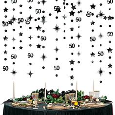 an image of a table setting with black and white stars on the wall behind it