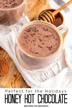 Photo of two glass mugs of hot chocolate topped with shaved chocolate, sitting next to a small bowl of honey with a wooden honey dipper and a tablespoon full of cocoa powder, all sitting on a wooden cutting board and white kitchen towel with text that says Perfect for the Holidays Honey Hot Chocolate. Honey Buttercream Frosting, Hot Christmas Drinks, Honey Buttercream, Drinks Christmas, Gluten Free Chocolate Recipes, Healthy Hot Chocolate, Vanilla Honey