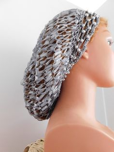 This quality specialty snood hair net is affordable and ships Fast. NO DRASTIC ELASTIC What's special about this one?  It is both handknit and crocheted by hand using designer threads/yarns.   Faux silver beads have been hand woven with silver metallic threads around the headband area.  We also placed a faux silver bead at the back crown area.   This snood (Fashion Hair Net) has been made for you using our own exclusive pattern.  We designed it. It is one-of-a-kind. Most all of our fashion hair nets are one size that fit most. They are stretchable and adjustable. We show you how to adjust.  We offer unlimited help after you purchase your fashion hair net from us!    Our net caps are designed for women to protect even the most luxuriant locks.  Keeps hair under control fashionably. We only Hair Nets, Net Lace, Thread & Yarn, Hair Net, Fashion Hair, Silver Bead, Head Covering, Metallic Thread, Simply Beautiful