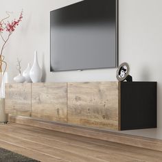 a flat screen tv mounted to the side of a wooden entertainment center in a living room