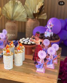 a table topped with cupcakes and other items on top of a wooden table