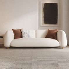 a white couch sitting on top of a rug in a living room next to a table