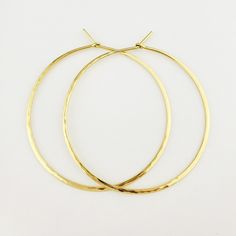 "Gorgeous Hammered Solid 18k Hoops made from 16 gauge (1.3mm) wire. 2\" Size photographed; 2\" size in 14k yellow gold shown in video METAL: Solid 18k Yellow Gold WIRE GAUGE/DIAMETER: 16 gauge (1.3mm) wire - Currently the thickest wire I offer EAR WIRE THICKNESS: Due to the thickness of the wire, the ear wire portion of the hoops will be tapered to approximately 18g, which is slightly thicker than standard ear wire thickness HAMMERED EFFECT: Each earring is made as a mirrored pair and the textur Yellow Gold Round Hoop Earrings For Celebration, Yellow Gold Brass Hoop Earrings For Gift, Handmade Yellow Gold Hoop Earrings Gift, Handmade Classic Yellow Gold Hoop Earrings, Elegant Yellow Gold Hoop Earrings For Celebration, Hammered 14k Gold-filled Hoop Earrings, Hand Forged 14k Gold Filled Gold Earrings, Hand Forged Yellow Gold Hoop Earrings, Handmade 14k Yellow Gold Hoop Earrings