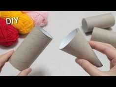 someone is making some paper cones out of toilet paper with yarn on the table next to them