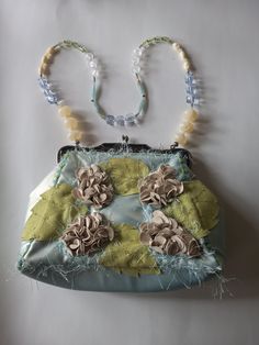 "This Mary Frances bag is just as beautiful as her other creations. This bag has a beautiful beaded chain to wear on the shoulder. It has a kiss lock clasp. There is a detailed ornamental design on the metal clasp bar. The feel of the purse is soft leather. There are suede appliques on the front and back of the bag, frilly-type threads around the bag, and tiny silk flowers. There are a couple of areas on the bag that show wear (indicated in the photos). There is another worn spot in the back tha Elegant Handmade Blue Shoulder Bag, Vintage Green Shoulder Bag For Party, Green Vintage Shoulder Bag For Party, Mary Frances Bags, State College Pa, Ornamental Design, Brown Satchel, Mary Frances, State College