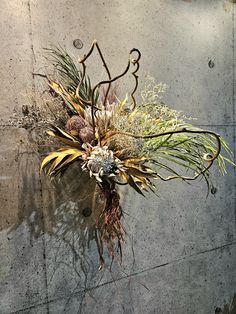 an arrangement of flowers is displayed on the wall