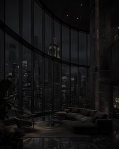 a living room filled with furniture and tall buildings in the background at night, lit up by lights on windows